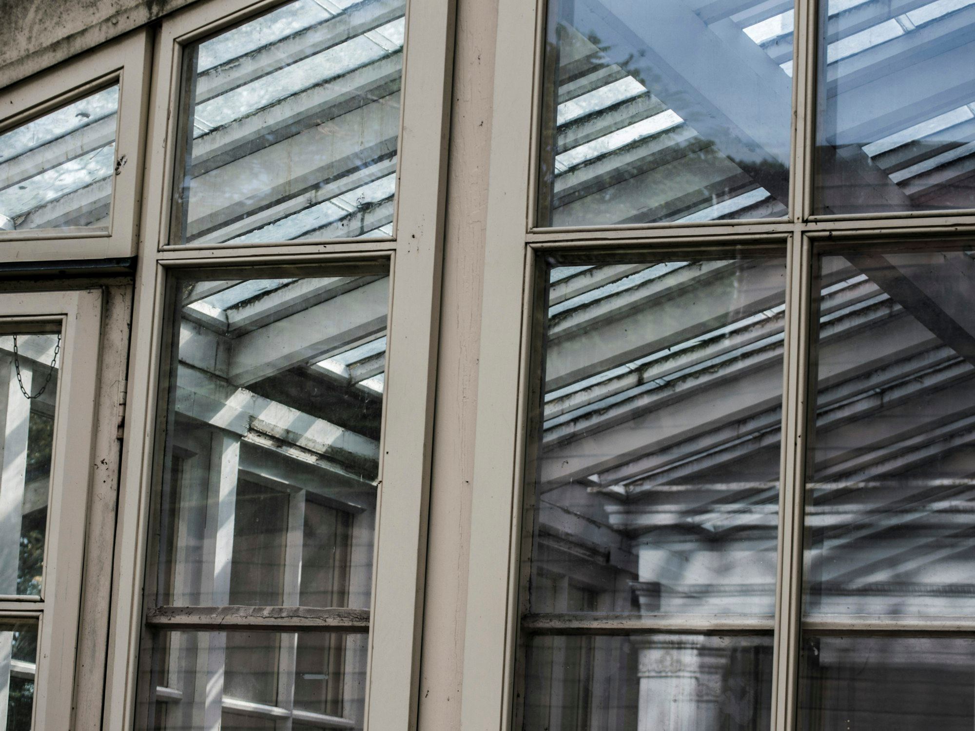 Close-up of a brown wooden window frame with a reflective glass roof.